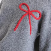 pull noeud compania fantastica jersey punto gris con detalle de lazo rojo pull manche longue gris uni avec un gros noeud brodé sur le coté en haut rouge